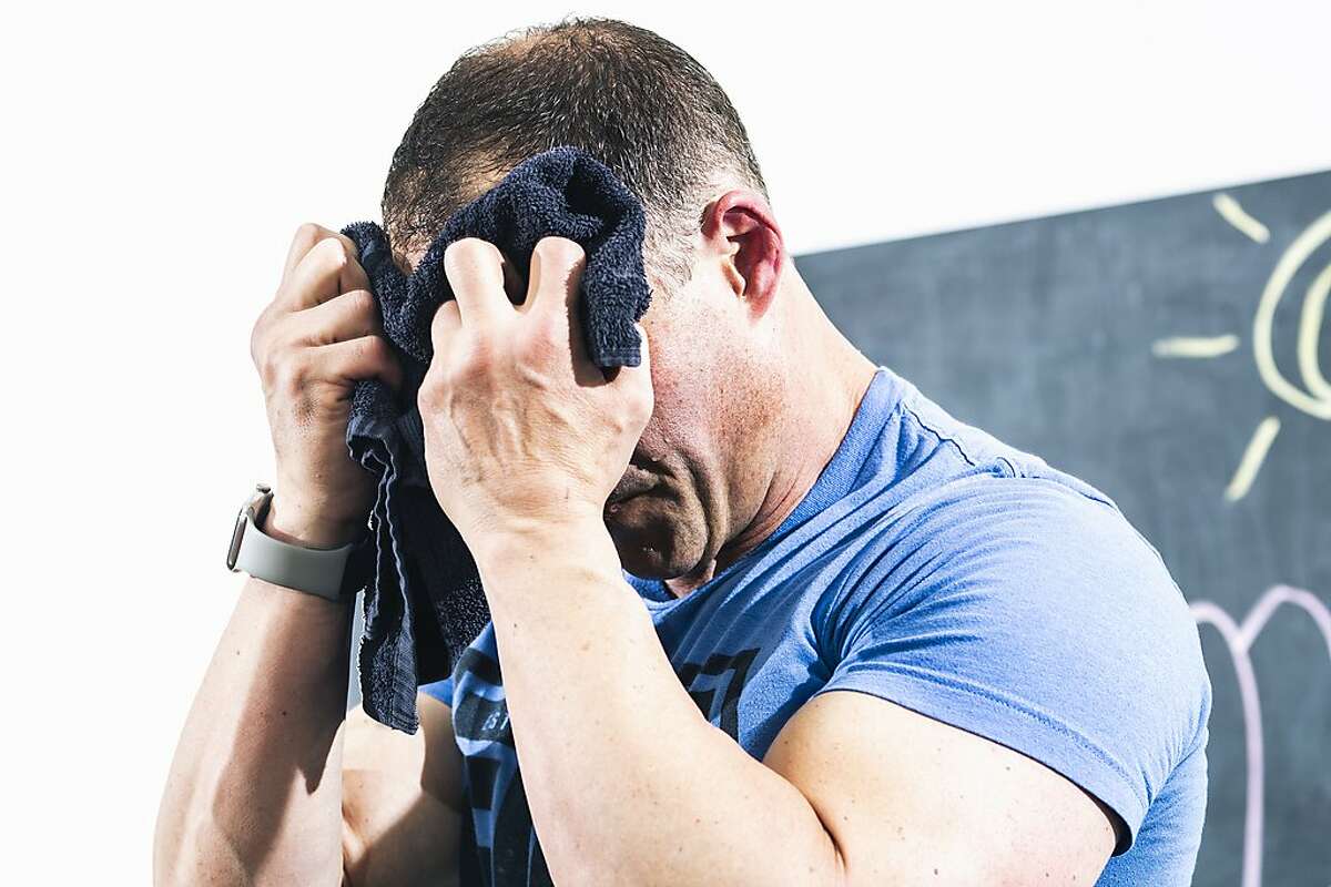 J.J. Miller, founder of The Firm Fitness, wipes away perspiration while leading a fitness class over Zoom on Wednesday, June 10, 2020 in San Francisco, California.