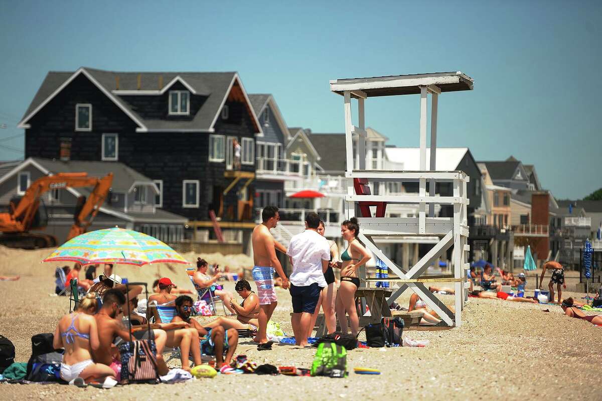 The lifeguard chair sits empty at a busy Silver Sands State Park beach in Milford, Conn. on Tuesday, June 19, 2018.