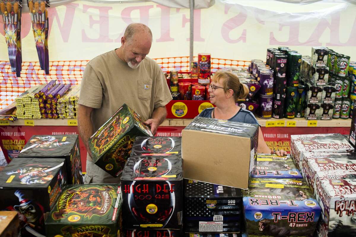 Midland residents Teri Johnson, right, and Troy Kerns, left, shop for fireworks Friday, June 26, 2020 at the Jake's Fireworks tent near the intersection of Patrick Road and Washington Street. (Katy Kildee/kkildee@mdn.net)