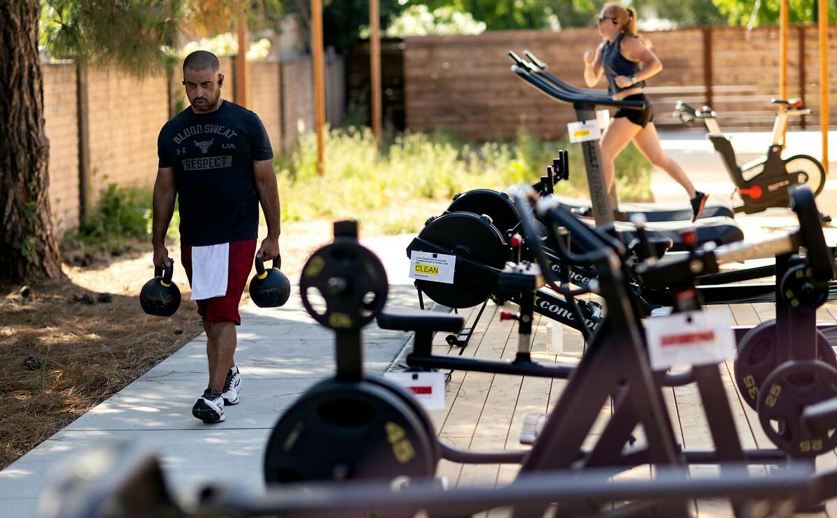 Members work out at an outdoor section of Sonoma Fitness in Petaluma, California on June 25, 2020.