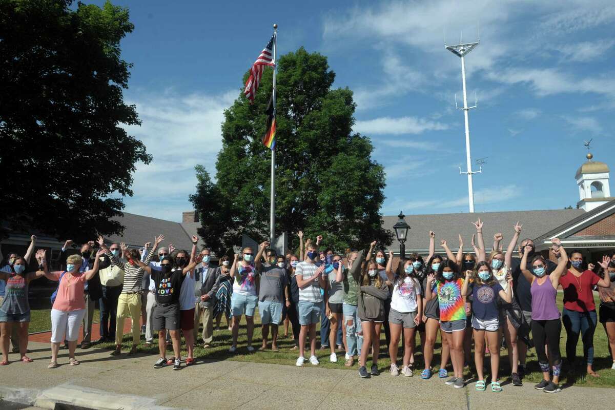 Several dozen people gathered to watch a rainbow pride flag raised in front of Town Hall, in Monroe, Conn. June 26, 2020. First Selectman Ken Kellogg also read a proclamation declaring Friday Pride Day.