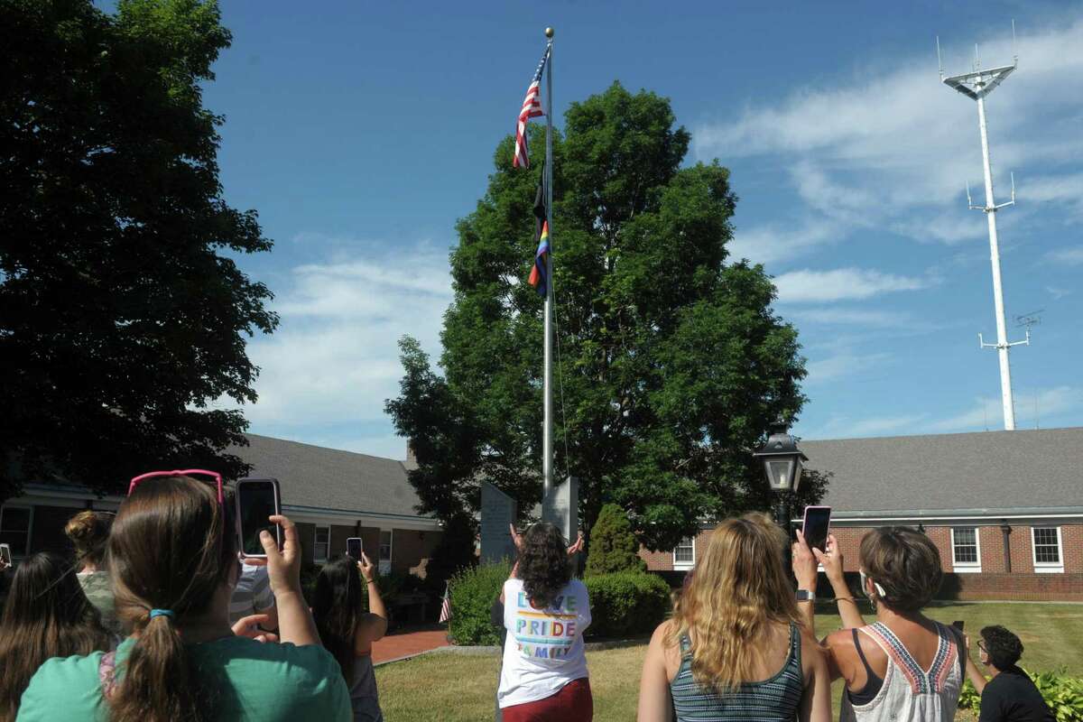 Several dozen people gathered to watch a rainbow pride flag raised in front of Town Hall, in Monroe, Conn. June 26, 2020. First Selectman Ken Kellogg also read a proclamation declaring Friday Pride Day.
