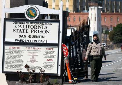A prison guard wears a mask at the main gate to San Quentin State Prison on Thursday,. The prison has experienced a huge coronavirus outbreak, with more than 600 inmates and about 90 staff members infected.