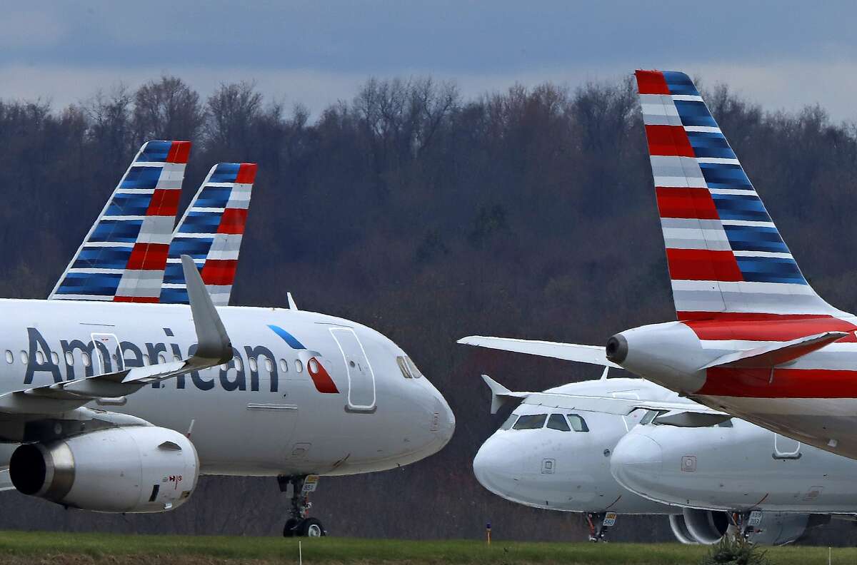 FILE - In this March 31, 2020 file photo American Airlines planes are parked at Pittsburgh International Airport in Imperial, Pa. There will be no more attempt at social distancing on American Airlines flights. The airline said Friday, June 26, that it will start booking flights to full capacity next week. (AP Photo/Gene J. Puskar, file)