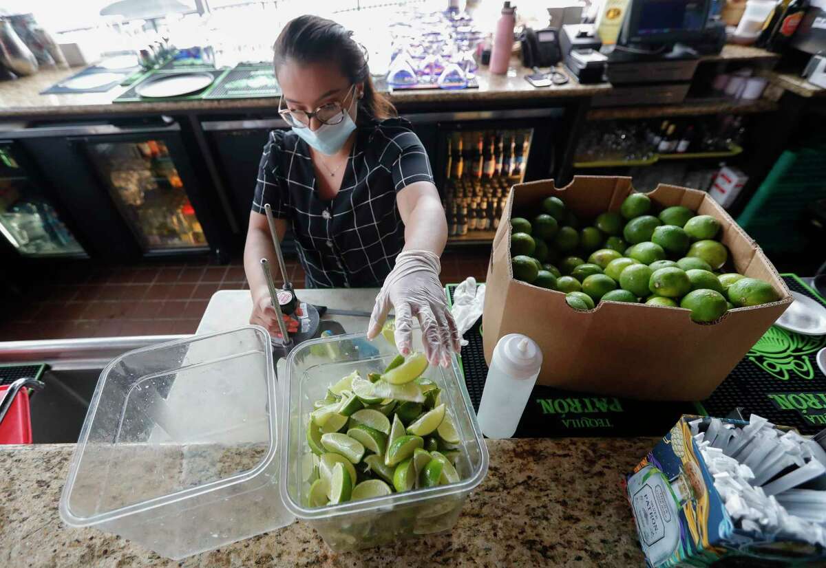 Bartender Meagan Oliver cuts limes at Fajita Jack's Tex-Mex Grill and Cantina, Saturday, June 27, 2020, in Montgomery. Gov. Greg Abbott order restaurants to reduce capacity from 75% to 50% beginning Monday in response to the growing number of coronavirus cases.