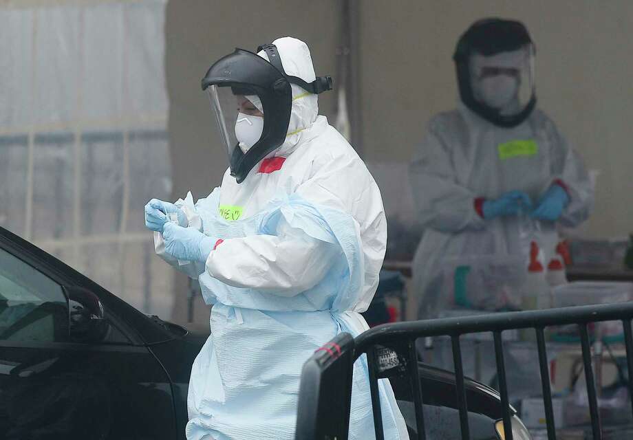 Medical personnel from Murphy Medical Associates administer drive-thru screenings for the COVID-19 coronavirus at a mobile testing site set up at Cummings Beach in Stamford, Conn. , March 20, 2020. Photo: Matthew Brown / Hearst Connecticut Media / Stamford Advocate