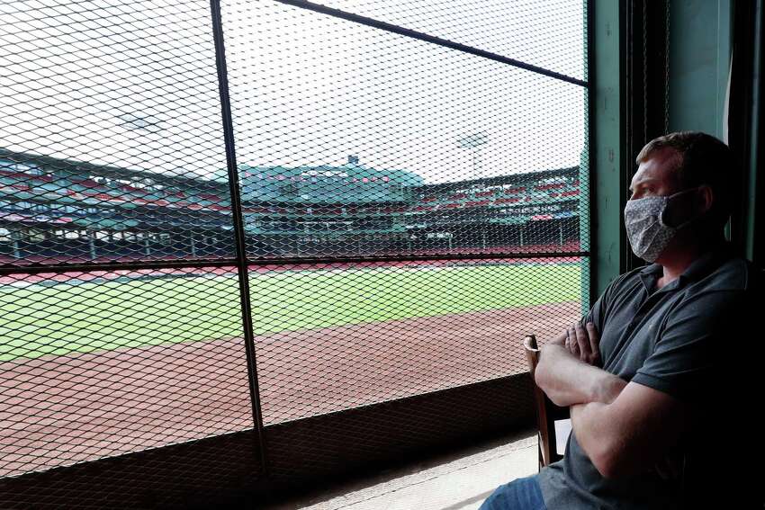 In this June 25, 2020, photo, Joe Hicks, Bleacher Bar director of operations, looks out at Fenway Park from the bar in Boston. Tucked under the center field seats at Fenway Park, down some stairs from Lansdowne Street in an area previously used as the visiting teama€™s batting cage, is a sports bar that is preparing to reopen from the coronavirus shutdown. If Major League Baseballa€™s plans remain on schedule, it may be one of the few places fans will be able to watch a game in person this season. (AP Photo/Elise Amendola)