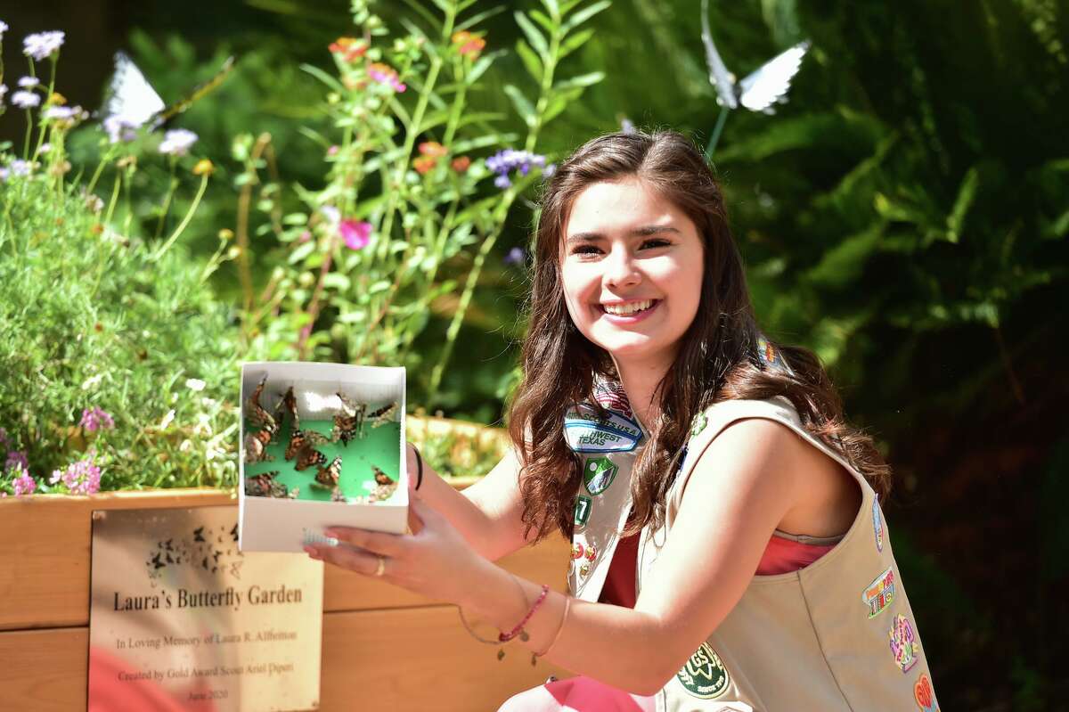 Girl Scout Ariel Diperi smiles and releases butterflies as she is recognized by the Children's Bereavement Center for handcrafting a butterfly garden for grieving children Saturday. The service included a butterfly release for 45 families unable to attend an infant loss remembrance service because of the coronavirus.