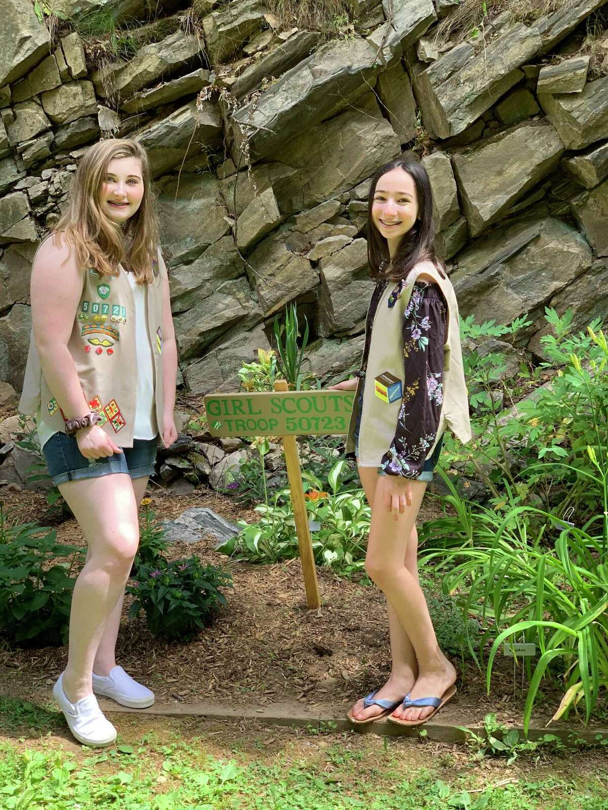 Saint Mary Ridgefield Troop 50723 Girl Scouts Julia Jamba and Isabella Raduazzo stand in front of the pollinator garden they installed at Congregate Housing Prospect Ridge, RHA.
