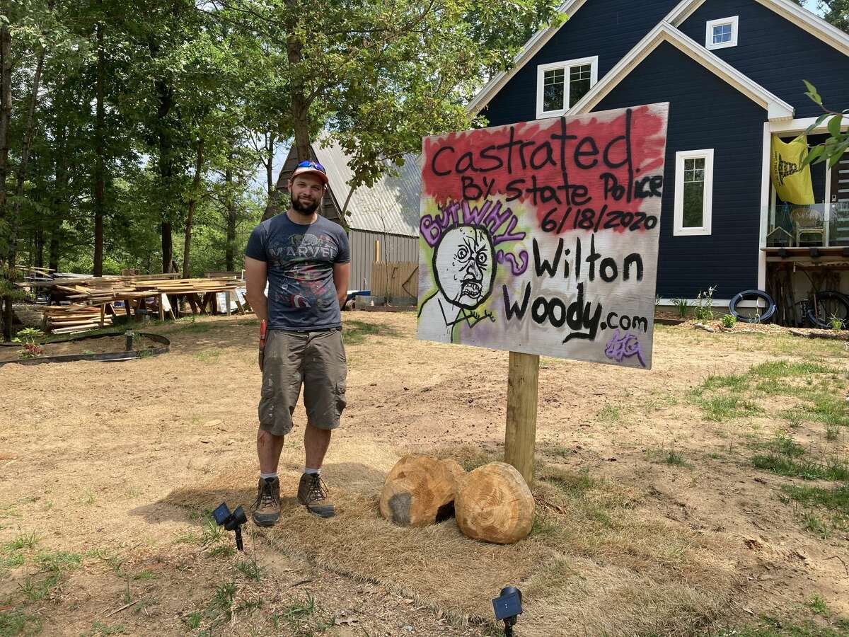 Jamie Gagne stands next to the remains of his 7-foot penis sculpture that was taken down in front of his house on Ruggles Road.