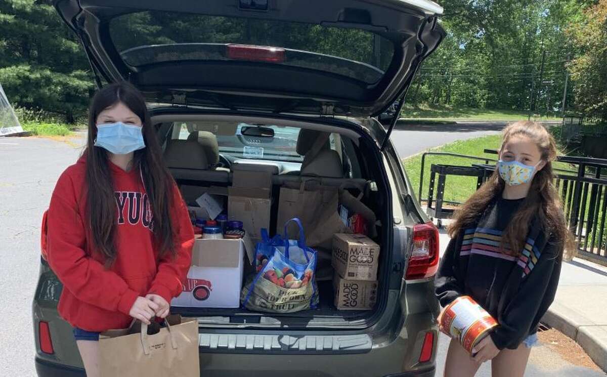 Wilton's Chloe Thompson, left, and Abby Jones, both students at Our Lady of Fatima Catholic Academy, deliver their food drive donations to the Wilton Food Pantry. June 2020