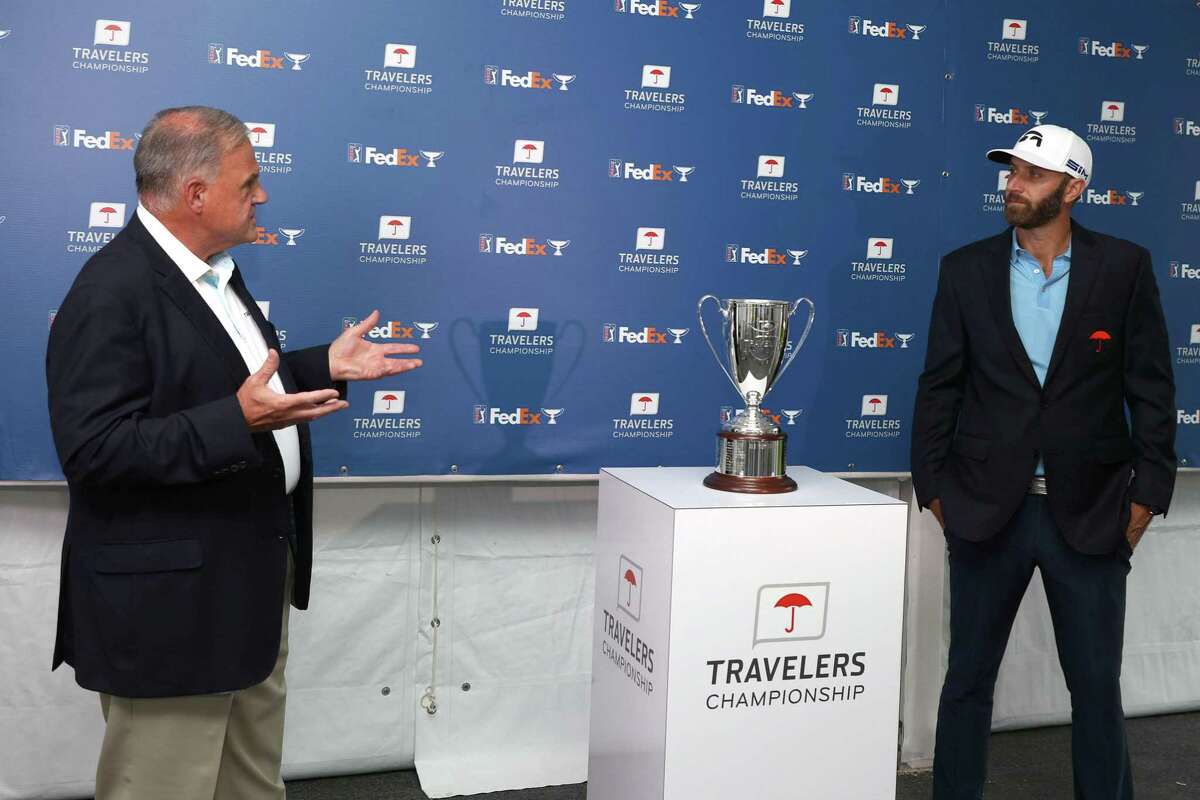 Dustin Johnson is presented with the trophy after winning the Travelers Championship Sunday in Cromwell.