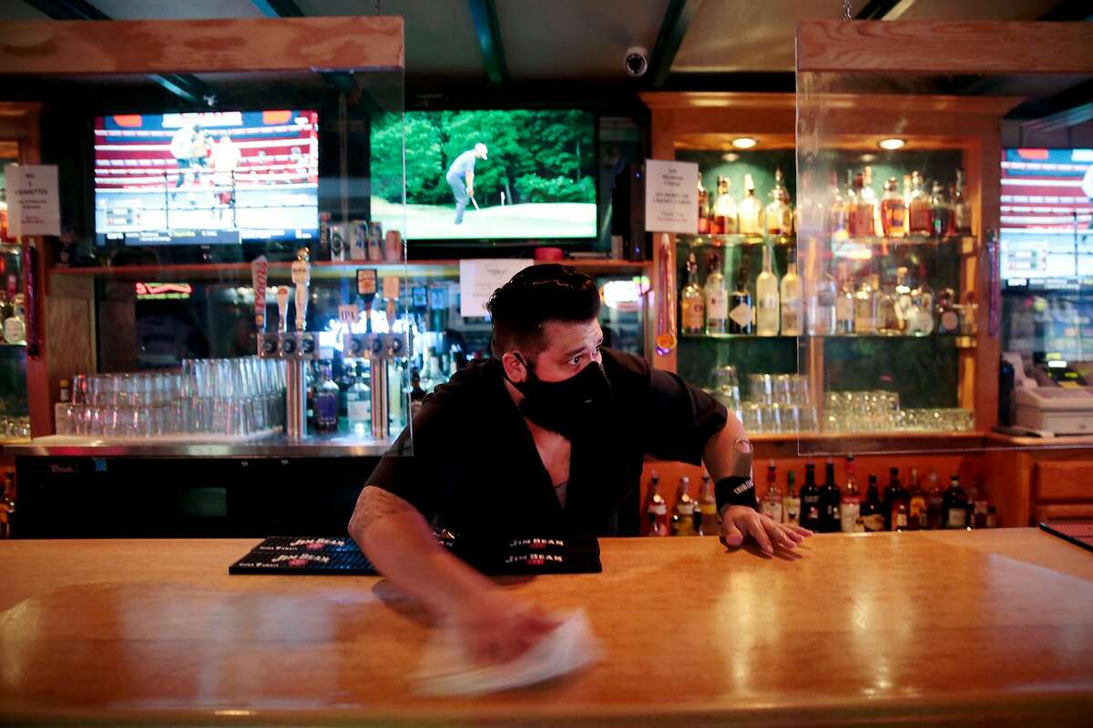 Manager Kevin Lemus cleans the bar at the Hideaway bar in Petaluma, California, Saturday, June 27, 2020.