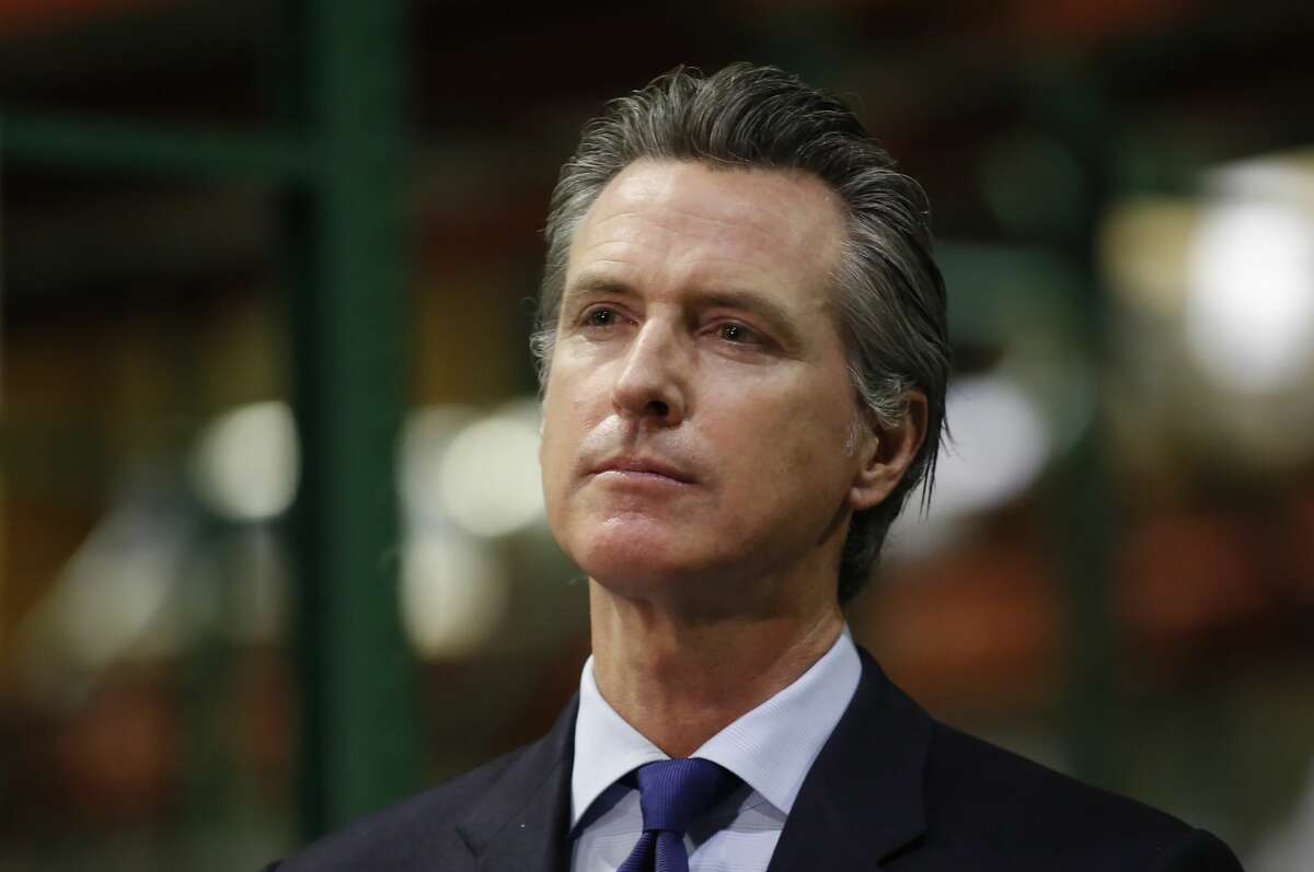 Gov. Gavin Newsom listens to a reporter's question during a news conference in Rancho Cordova, Calif., Friday, June 26, 2020. Newsom has pardoned 13 former prisoners, including three whose immigration status may benefit. He also commuted the sentences of 21 current inmates on Friday, including several who killed their victims and had been serving life-without-parole sentences.