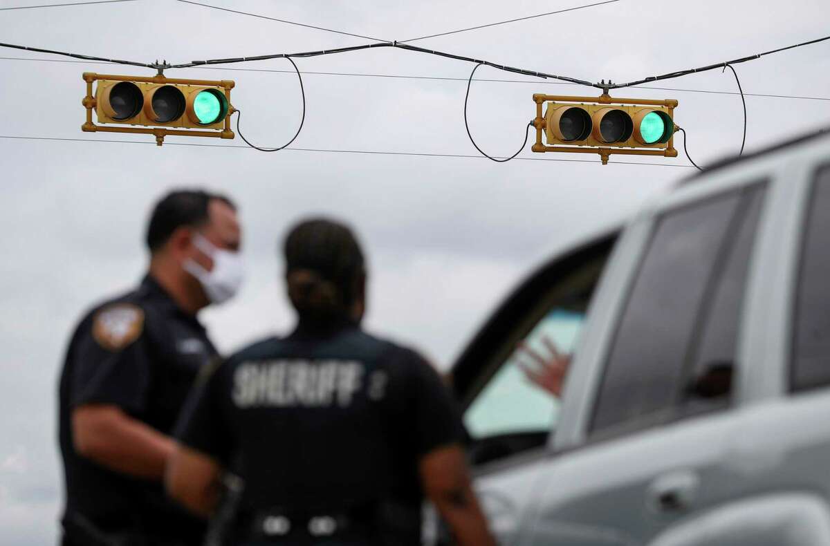 Harris County Sheriff's deputies Aaron Herrera, left, Nakeitha Dussette speak to a woman after Dussette initiated a traffic stop Wednesday, June 24, 2020, at the intersection of Bellaire Boulevard and Metro Boulevard in Houston.