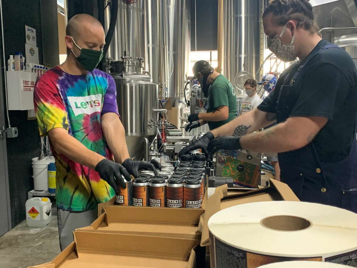 Employees of Weathered Souls Brewery package cases of its Black is Beautiful stout in San Antonio on Monday, June 29, 2020. The initiative behind the beer has grown from the local brewery's call for social justice into a worldwide campaign.