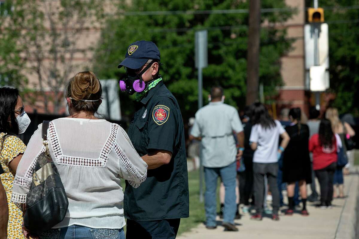 Temporary walk-up testing sites like this one held last week at Will Rogers Academy are drawing long lines of people. Danny Fencl, with the San Antonio Fire Department/Mobile Integrated Healthcare Program, hands out wristbands for COVID-19 tests last week. Often there are more people than tests available.