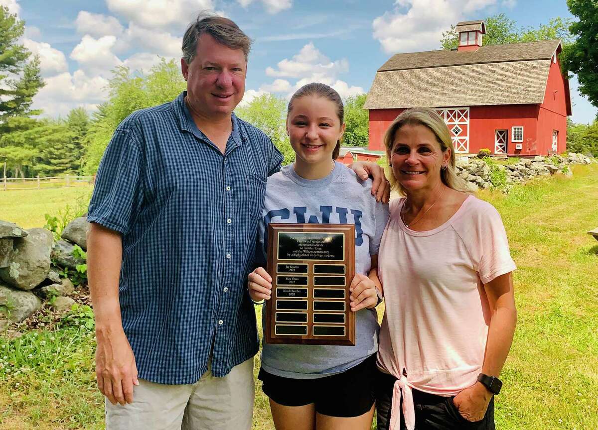 Nicole Beecher, shown with her parents James and Sharon Beecher, holds the plaque recognizing her as the recipient of Ambler Farm's 2020 Raymond-Ambler Award.