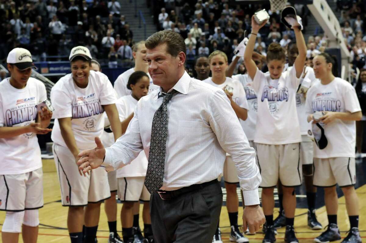 UConn coach Geno Auriemma walks to receive an award after his team defeated West Virginia 60-32 to win the 2010 Big East tournament championship.