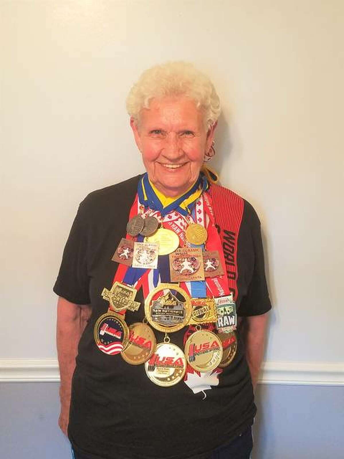 Rosewood Heights resident Shirley Webb, 82, wearing 17 of her 18 medals. The “weightlifting grandma,” as described in the book “Ripley’s Believe It or Not! Shatter Your Senses!,” since Dec. 9, 2016, when her son, Kent Webb, started recording and tracking the total amount of weights lifted, has lifted more than four million pounds, as of this past May.