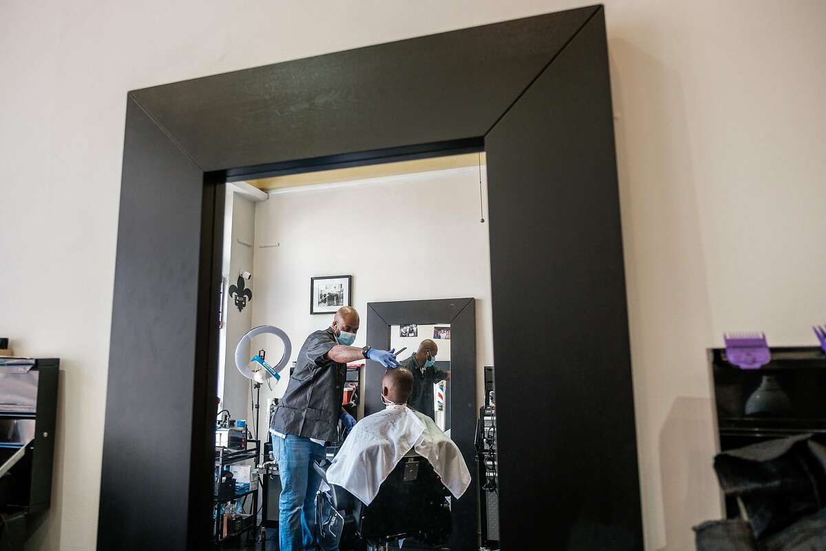 Barber Lennotch Taplett cuts long time customer Brian Hill’s hair at Details Barbershop & Grooming Lo in San Francisco on Tuesday, June 30, 2020.