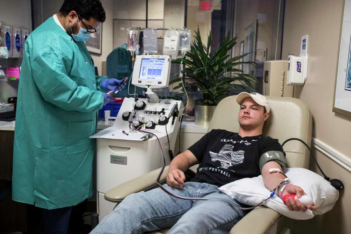 Alfredo Gutierrez, left, works with a blood sample he just drew from Conner Scott's arm as Scott donates plasma at Houston Methodist Hospital on Friday, May 15, 2020 in Houston. The coronavirus pandemic has affected hospital revenues as staff must reschedule elective procedures.