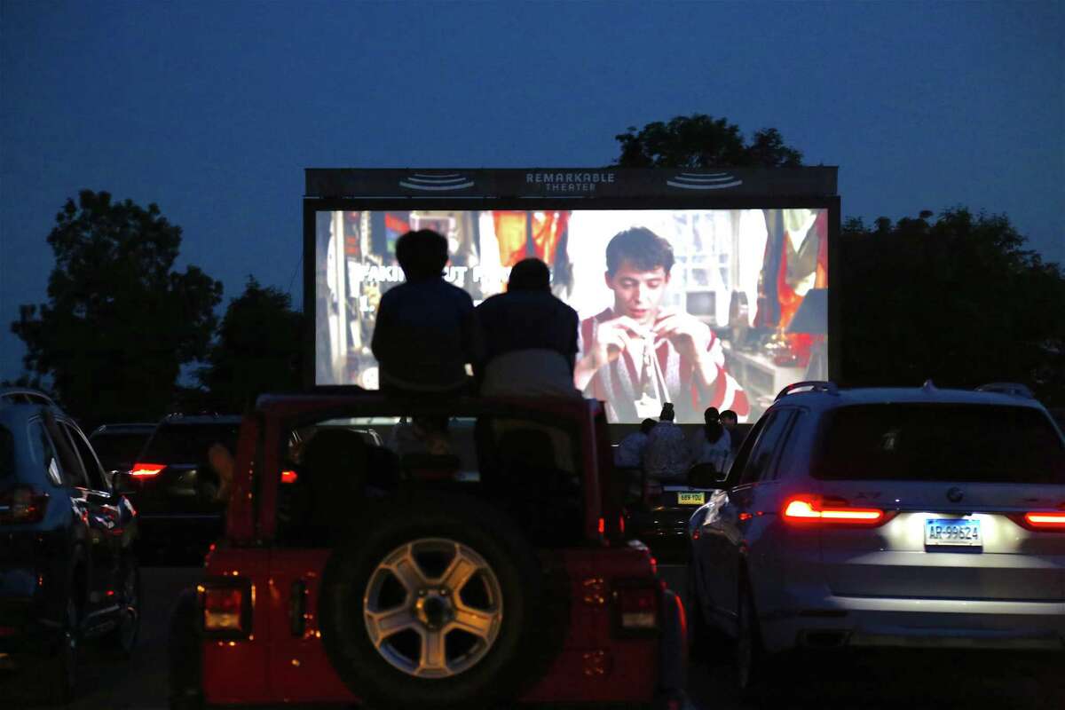 Viewers atop their car at the drive-in premiere of the new Remarkable Theater on Friday, June 27, 2020, in Westport, Conn.