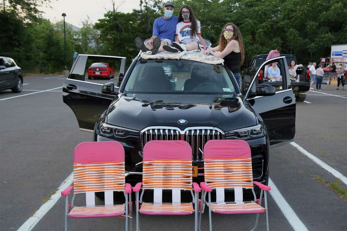 Getting a better seat are, from left, Jeff Hellinger of Weston, Sydney, and Deborah at the drive-in premiere of the new Remarkable Theater on Friday, June 27, 2020, in Westport, Conn.