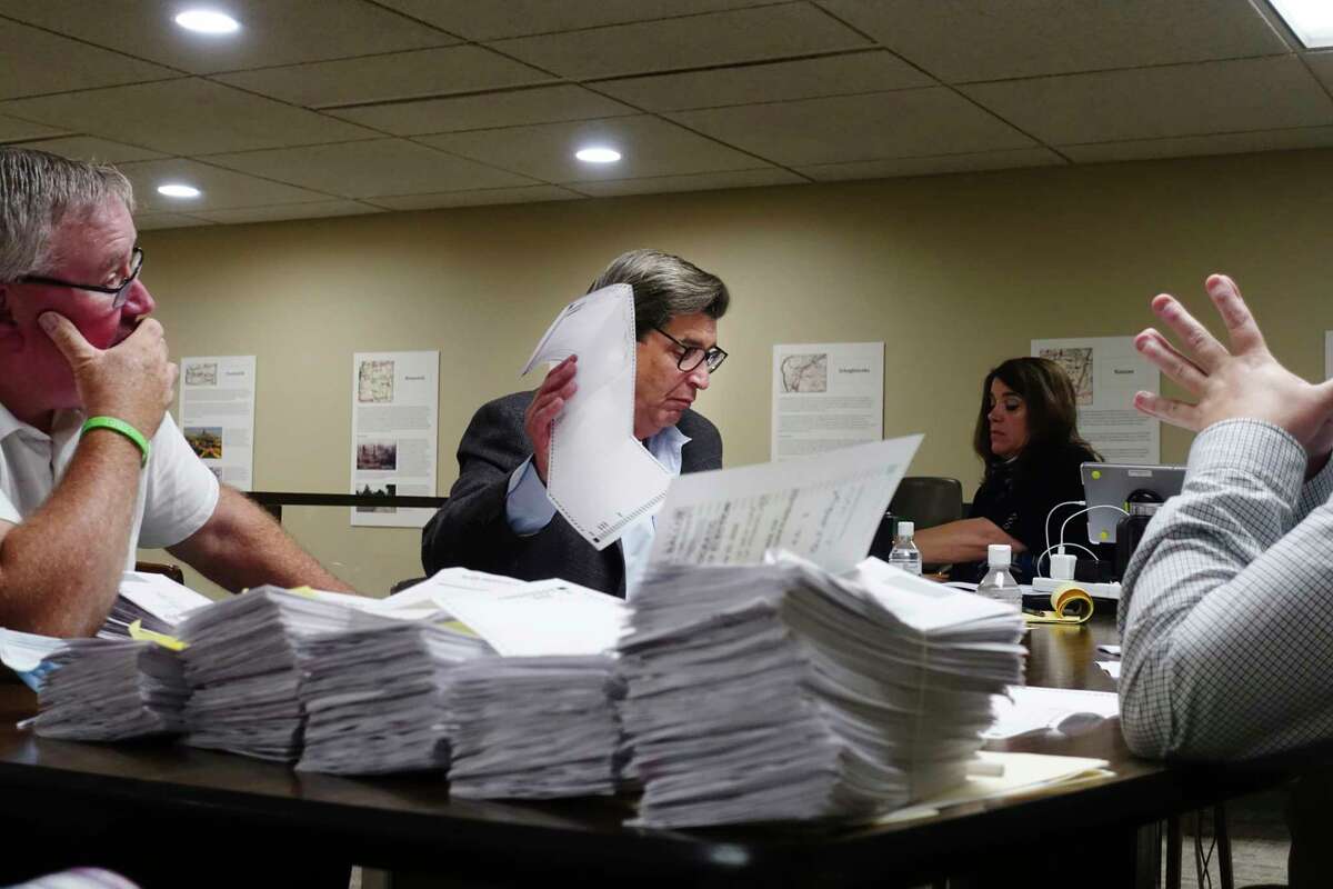 Robert Harding, center, representing Assemblyman John McDonald III, looks over absentee ballots as employees of the Rensselaer County Board of Elections began counting the ballots on Wednesday, July 1, 2020, in Troy, N.Y. Assemblyman McDonald is running against Sam Fein in the 198th Assembly District race. (Paul Buckowski/Times Union)