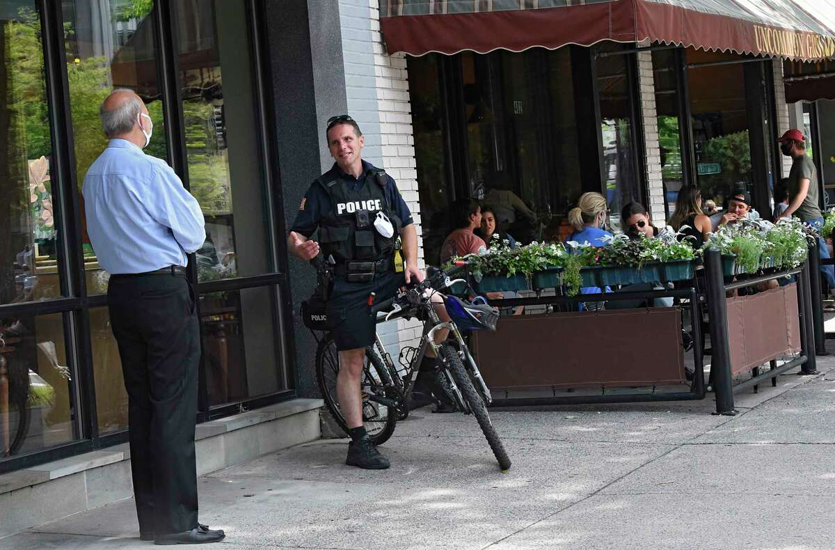 A police officer is seen chatting with a man on Broadway on Wednesday, July 1, 2020 in Saratoga Springs, N.Y. (Lori Van Buren/Times Union)