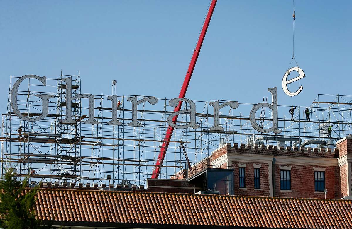 The iconic sign above Ghirardelli Square is removed one letter at a time in San Francisco, Calif. on Wednesday, July 1, 2020. The aging illuminated characters will be replicated and replaced with new ones.