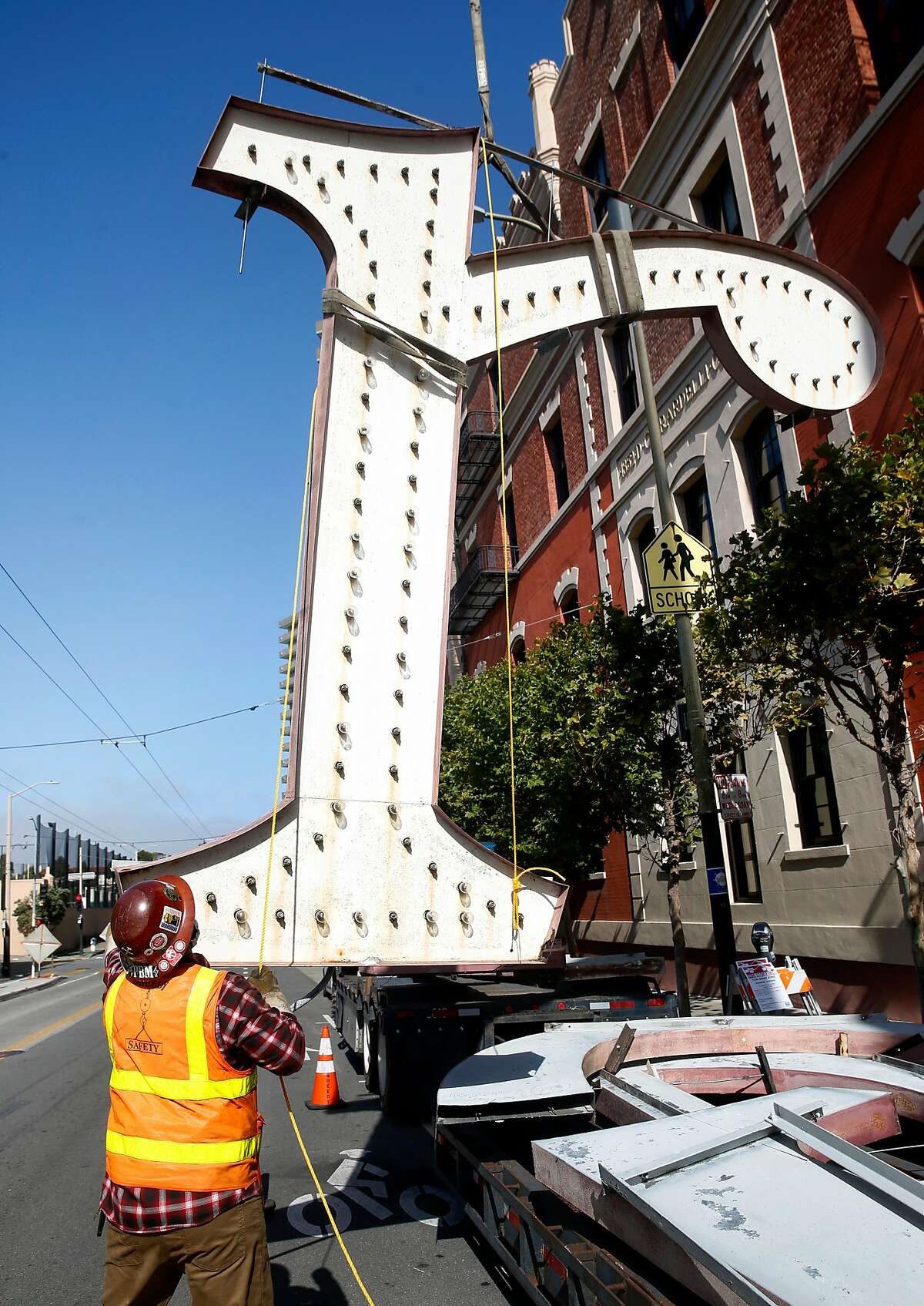 A letter from the iconic Ghirardelli Square sign is lowered onto a flatbed truck after it’s removed from the roof in San Francisco, Calif. on Wednesday, July 1, 2020. The aging illuminated characters will be replicated and replaced with new ones.