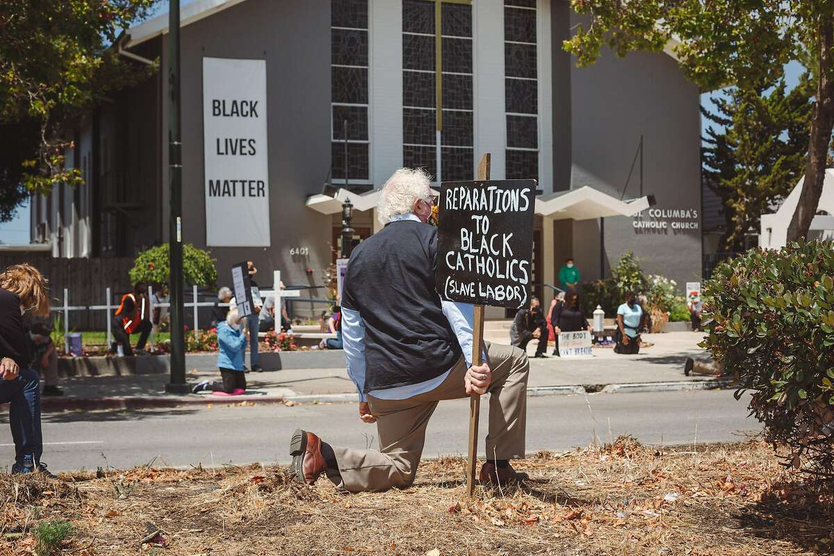 Parishoners participate in a Black Lives Matter protest outside of St. Columba Catholic Church in Oakland, Calif. on Sunday, June 28, 2020.