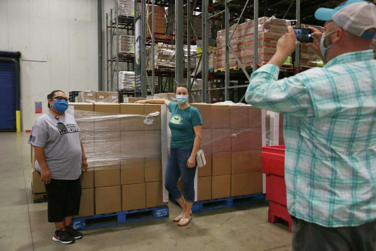 CR8AD8 Dispatch Manager Lauren Lear, center, poses with San Antonio Food Bank Produce Procurement Manager Dayna Robokowski after delivering several pallets of produce boxes, Friday, June 5, 2020. The delivery is part of the USDA/CR8AD8 $39 million contract to deliver 750,000 boxes of produce and protein by the end of June. Friday's shipment brought the total to 4,121 boxes delivered to the food bank so far.