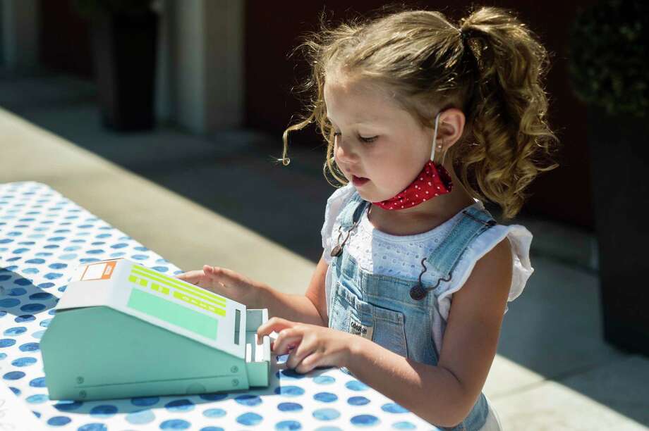 Ellie Martindale, 6, demonstrates Wednesday how she uses the cash register at her lemonade stand, which raised $250 for flood relief. (Katy Kildee/)