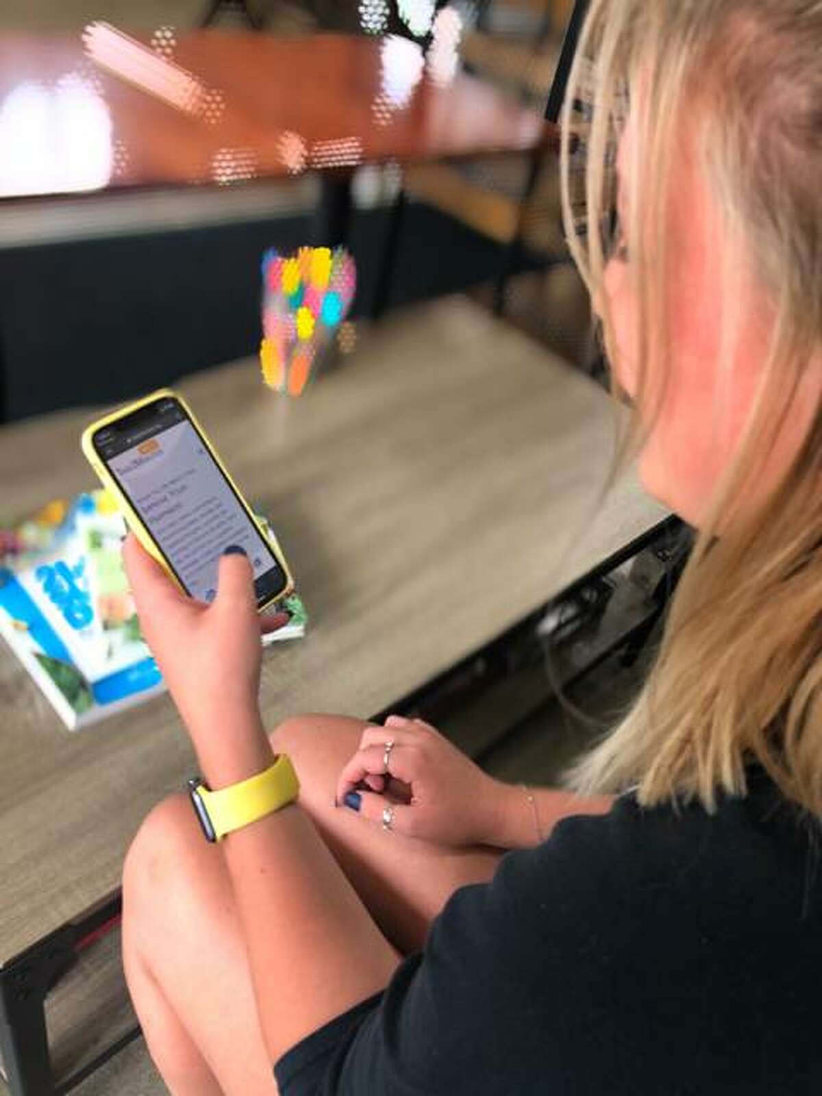 A woman uses her cellphone to read content on Take2Minutes, a free text messaging service designed to provide and positive messages, guided meditations and other activities for users. The idea is the brainchild of Edwardsville native Marc Fussell.