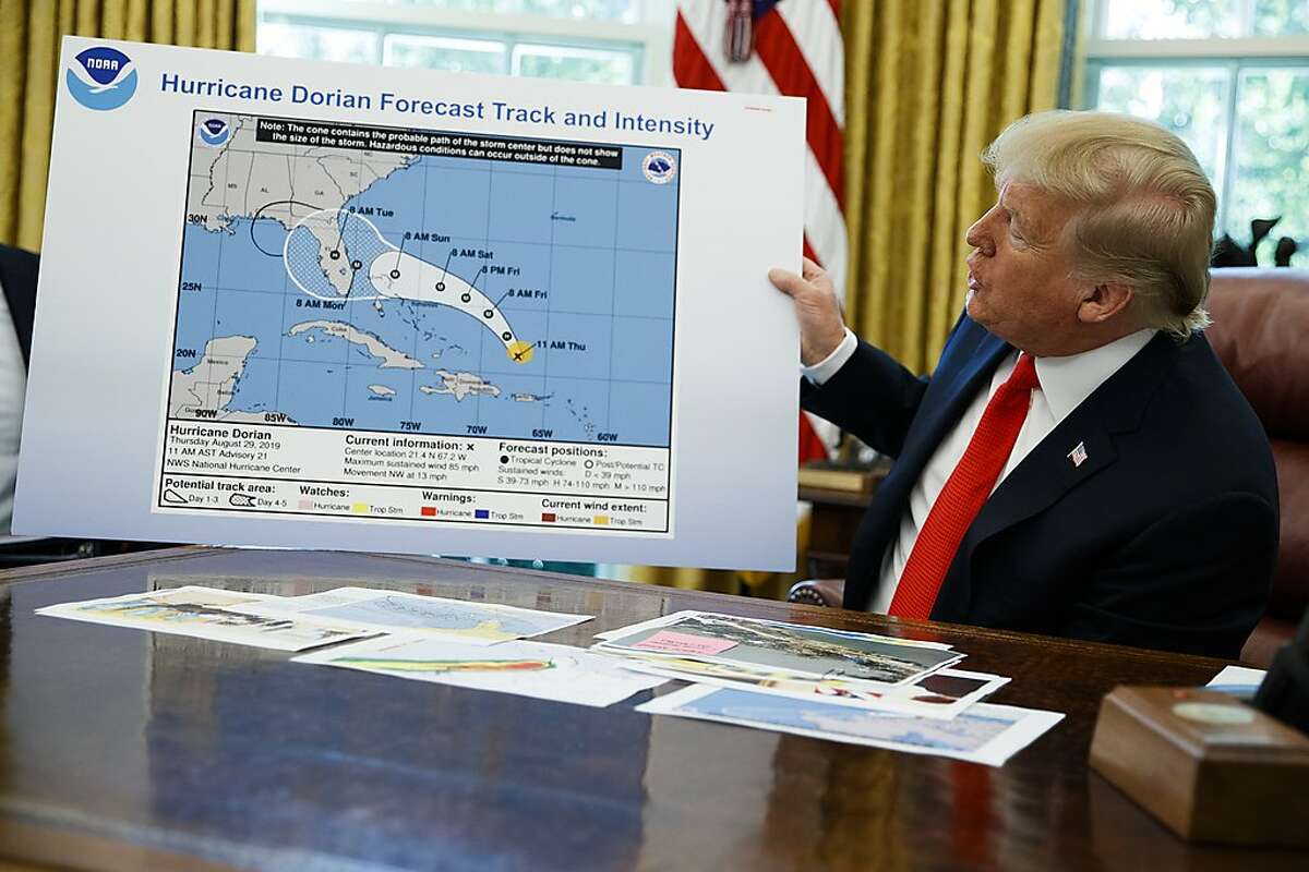 FILE - In this Wednesday, Sept. 4, 2019 file photo, President Donald Trump holds a chart as he talks with reporters after receiving a briefing on Hurricane Dorian in the Oval Office of the White House in Washington. A report from the National Academy of Public Administration released on Monday, June 15, 2020 says that NOAA’s acting chief Neil Jacobs and its then-communications director, Julie Kay Roberts, twice breached the agency’s rules designed to protect scientists and their work from political interference, putting out a press statement that “did not follow NOAA’s normal proves and appear to be the result of strong external pressure.” (AP Photo/Evan Vucci)