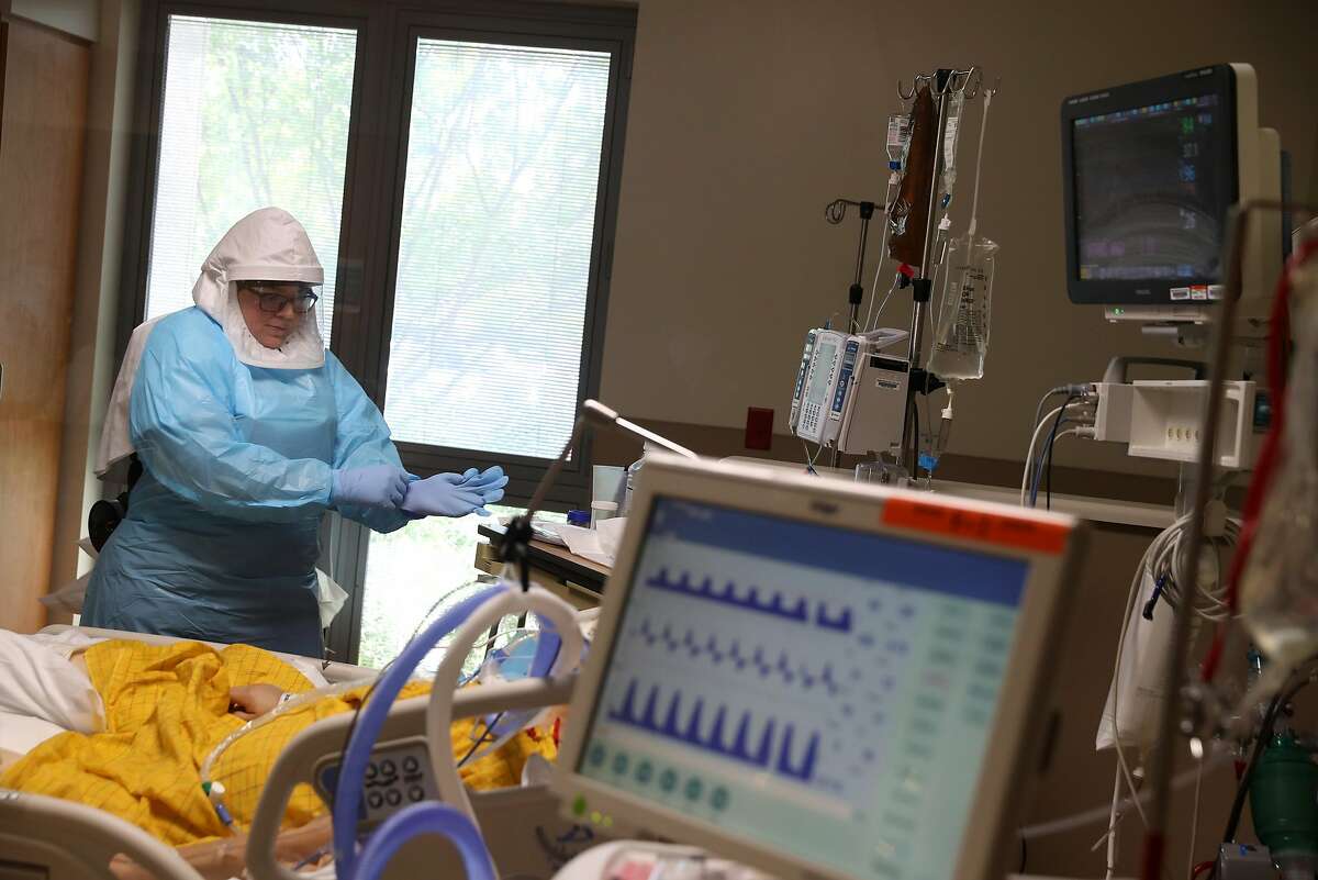 SAN JOSE, CALIFORNIA - MAY 21: (EDITORIAL USE ONLY) A nurse wears personal protective equipment (PPE) as she cares for a coronavirus COVID-19 patient in the intensive care unit (I.C.U.) at Regional Medical Center on May 21, 2020 in San Jose, California. F