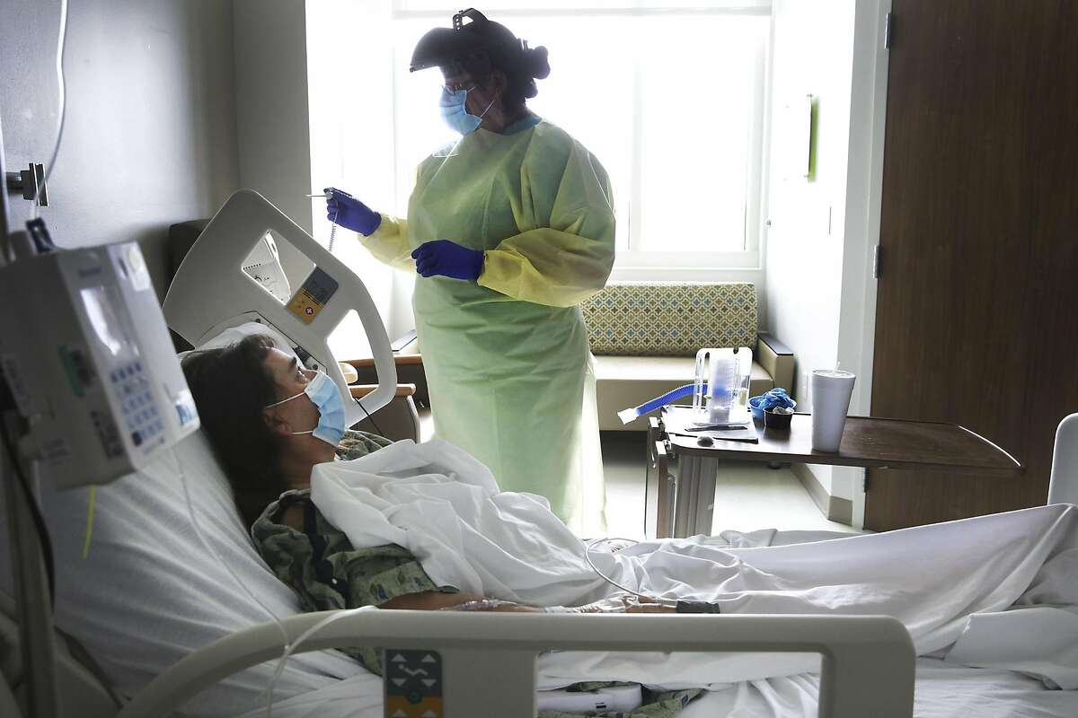 Nurse Olivia Rocha, prepares to take the temperature of Betty Talton, who is also taking a new tool against coronavirus, remdesivir, in University Hospital Covid Unit, on Tuesday, June, 2, 2020.