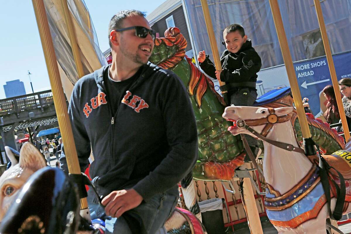 From left: Jesse Trevino and his son Ryland Trevino, 5, who are visiting from Nebraska, ride the carousel at Pier 39 on Thursday, March 14, 2019, in San Francisco, Calif.