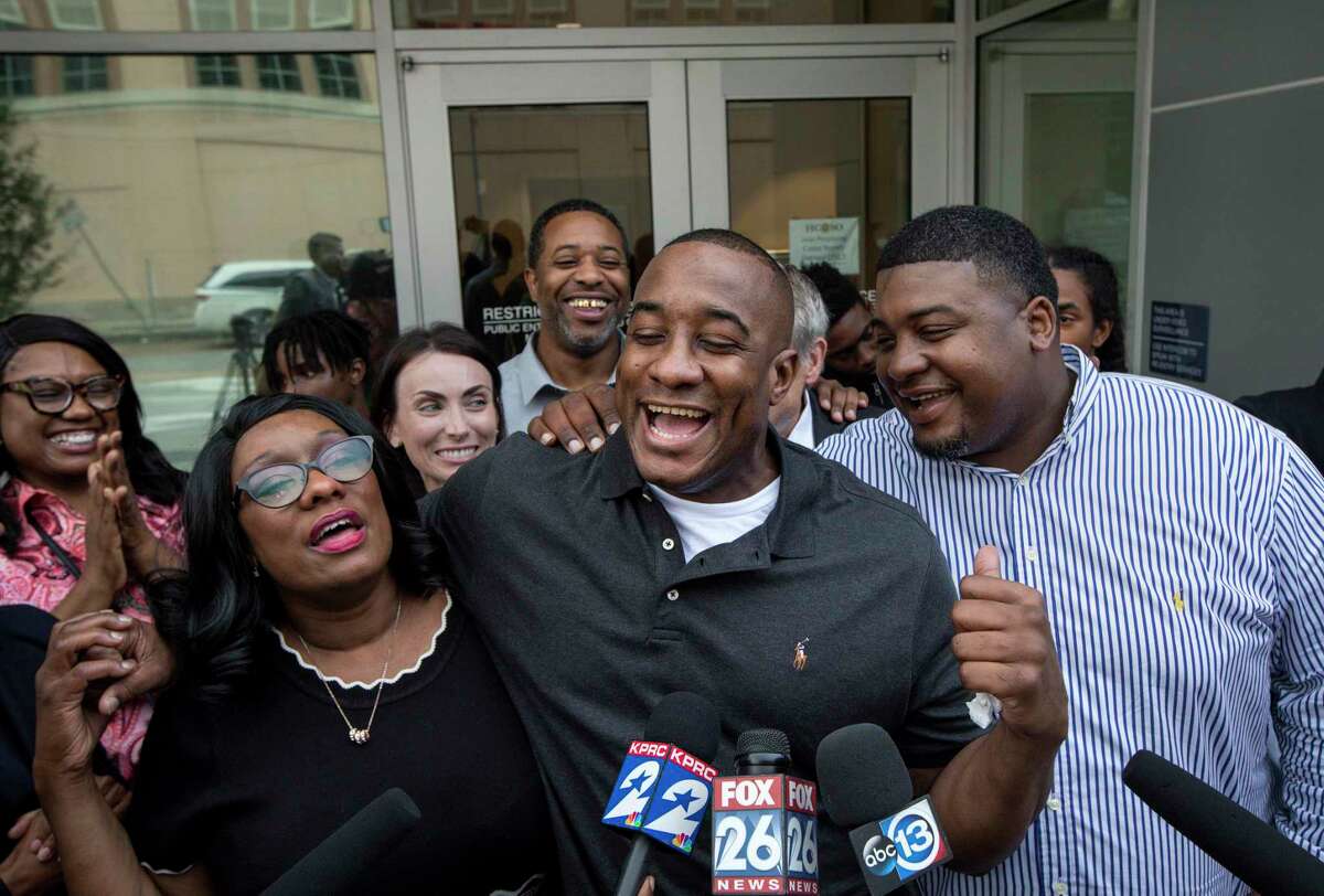 Lydell Grant, center, his mother Donna Poe, center-left, and brother Alonzo Poe, center-right, talk to reporters after Grant's release on bond on Tuesday, Nov. 26, 2019, in Houston. Earlier in the day, Grant was ordered released on bond after prosecutors and defense attorneys with the Innocence Project of Texas agreed that Grant should be released while the case is investigated further in light of new DNA evidence. Grant was convicted of capital murder in the 2010 stabbing death of Aaron Scheerhoorn outside of a Montrose bar, and he had spent seven years behind bars.