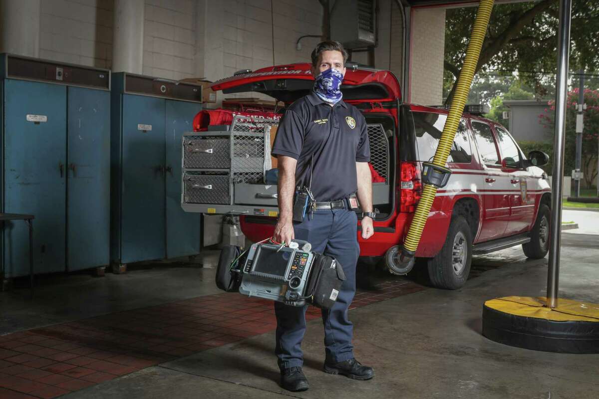 Houston Fire Department Capt. Daniel Soto poses behind his vehicle he uses to respond to emergencies Friday, July 3, 2020, in Houston.