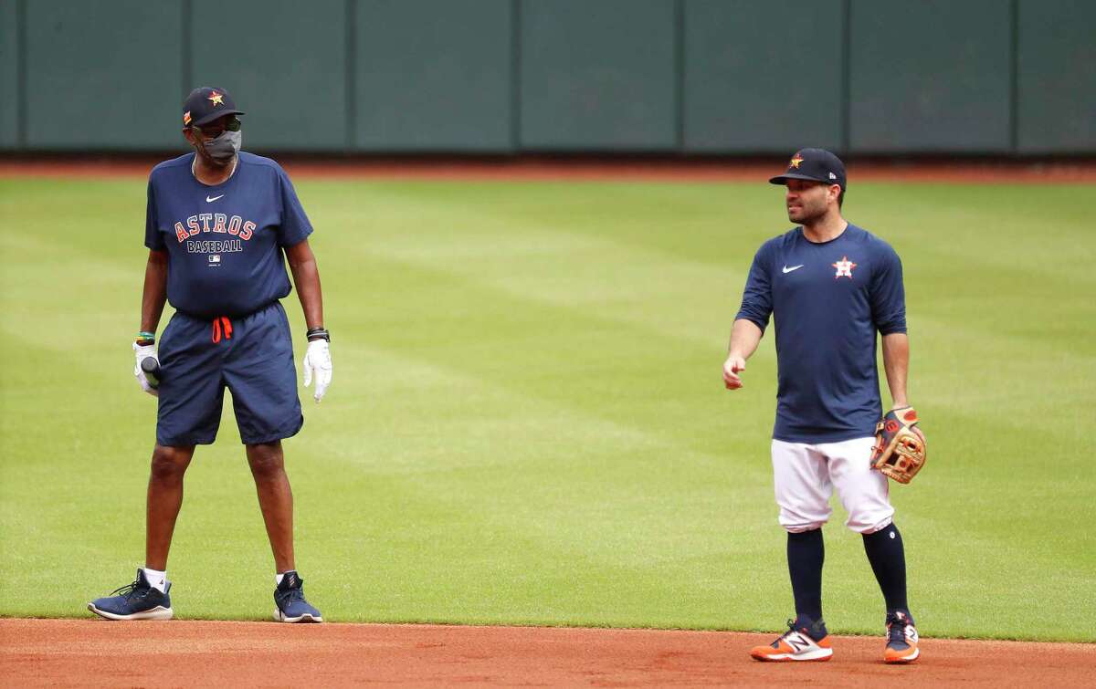 Houston Astros manager Dusty Baker wears a mask as he chats with second baseman Jose Altuve during the first day of the Houston Astros Summer Camp at Minute Maid Park on Friday.