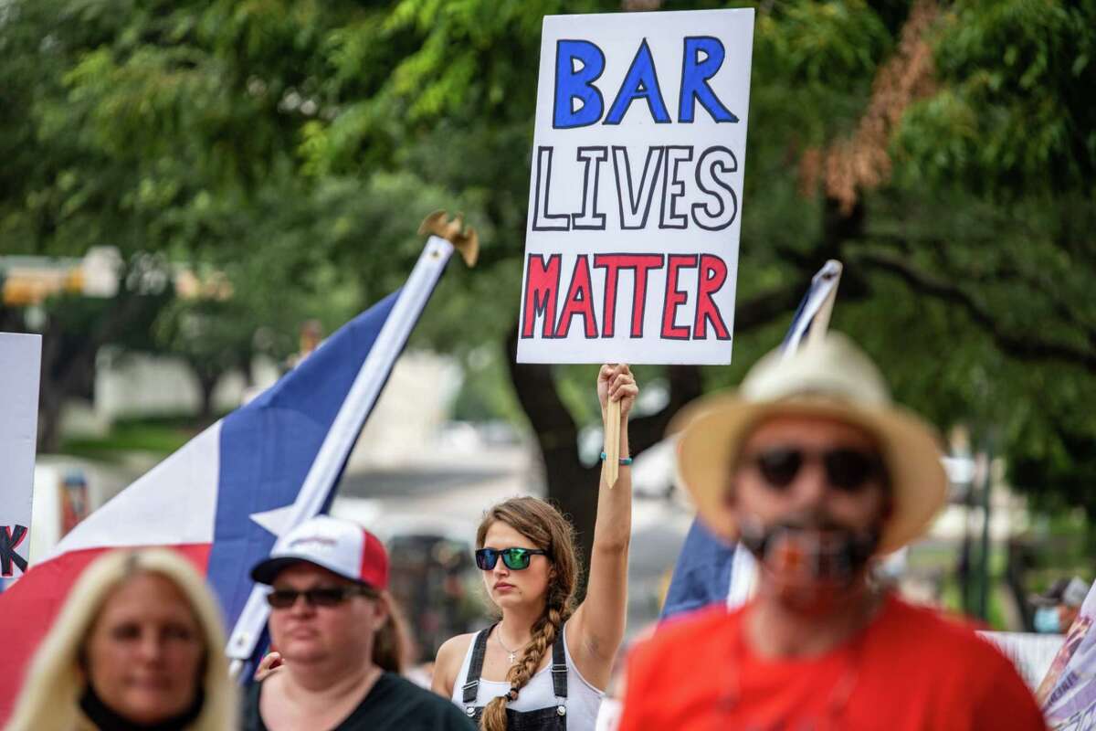 A demonstrator holds up a sign during a "Bar Lives Matter" protest in Austin, Texas, on June 30, 2020. MUST CREDIT: Bloomberg photo by Sergio Flores