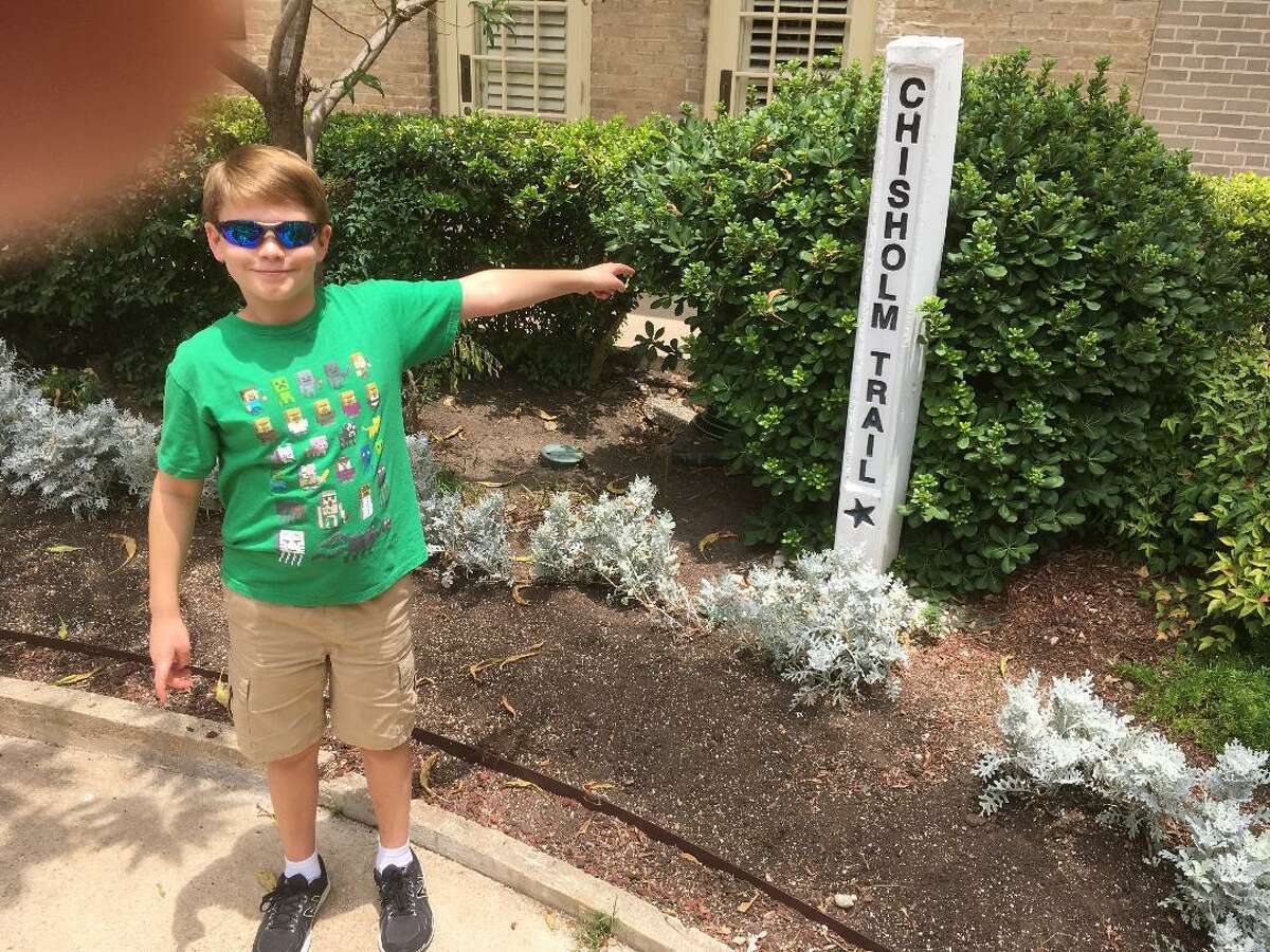 Nicholas Neumann, 9, points to the Chisholm Trail marker at the Menger Hotel. While most experts agree that the original trail was never in Texas, this marker, and others like it from Brownsville up to the Texas-Oklahoma state line, commemorate the many connections throughout the state to the days of the great Texas cattle drives.