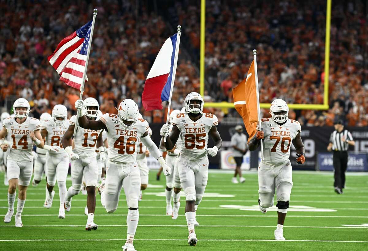 Texas Longhorns Joseph Ossai (46), Malcolm Epps (85) and Christian Jones (70) carry the flags out upon entrance to the field prior to start of game against the Rice Owls on September 14, 2019, at NRG Stadium in Houston, Texas.