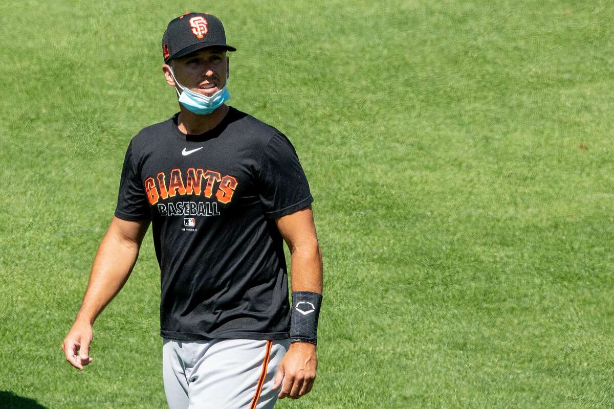 San Francisco Giants catcher Buster Posey wears a mask around his chin while participating in the San Francisco Giants' summer training camp session at Oracle Park in San Francisco, Calif. Saturday, July 4, 2020. Due to COVID-19, the 2020 MLB season has been postponed with players just beginning to return for warmups and practices while wearing masks and keeping social distance.