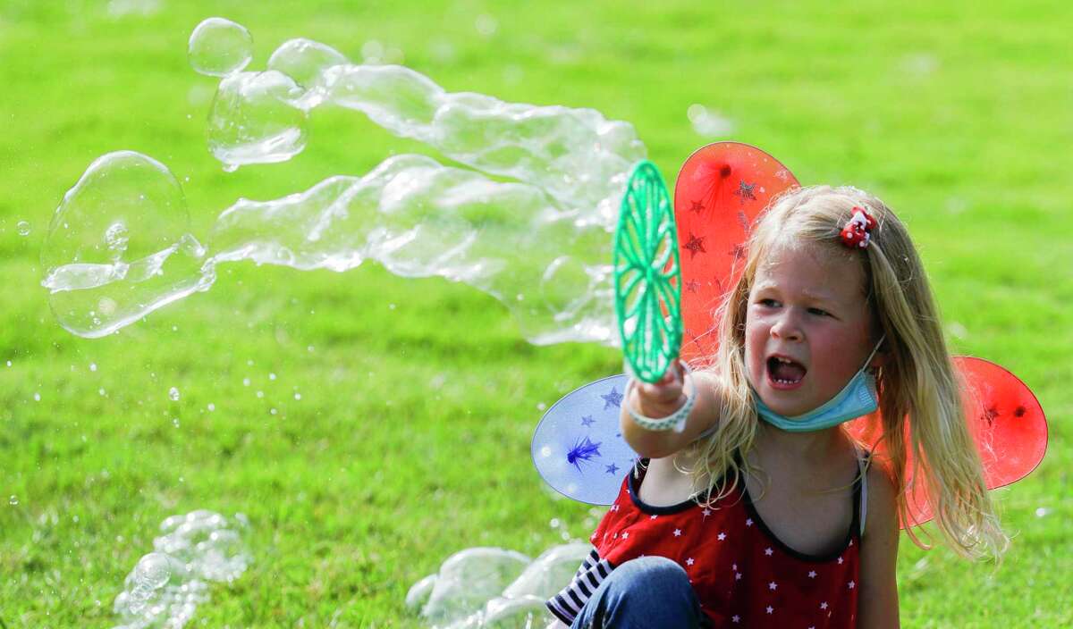 Evelyn Muessig, 4, plays with bubbles during a Fourth of July celebration Saturday.