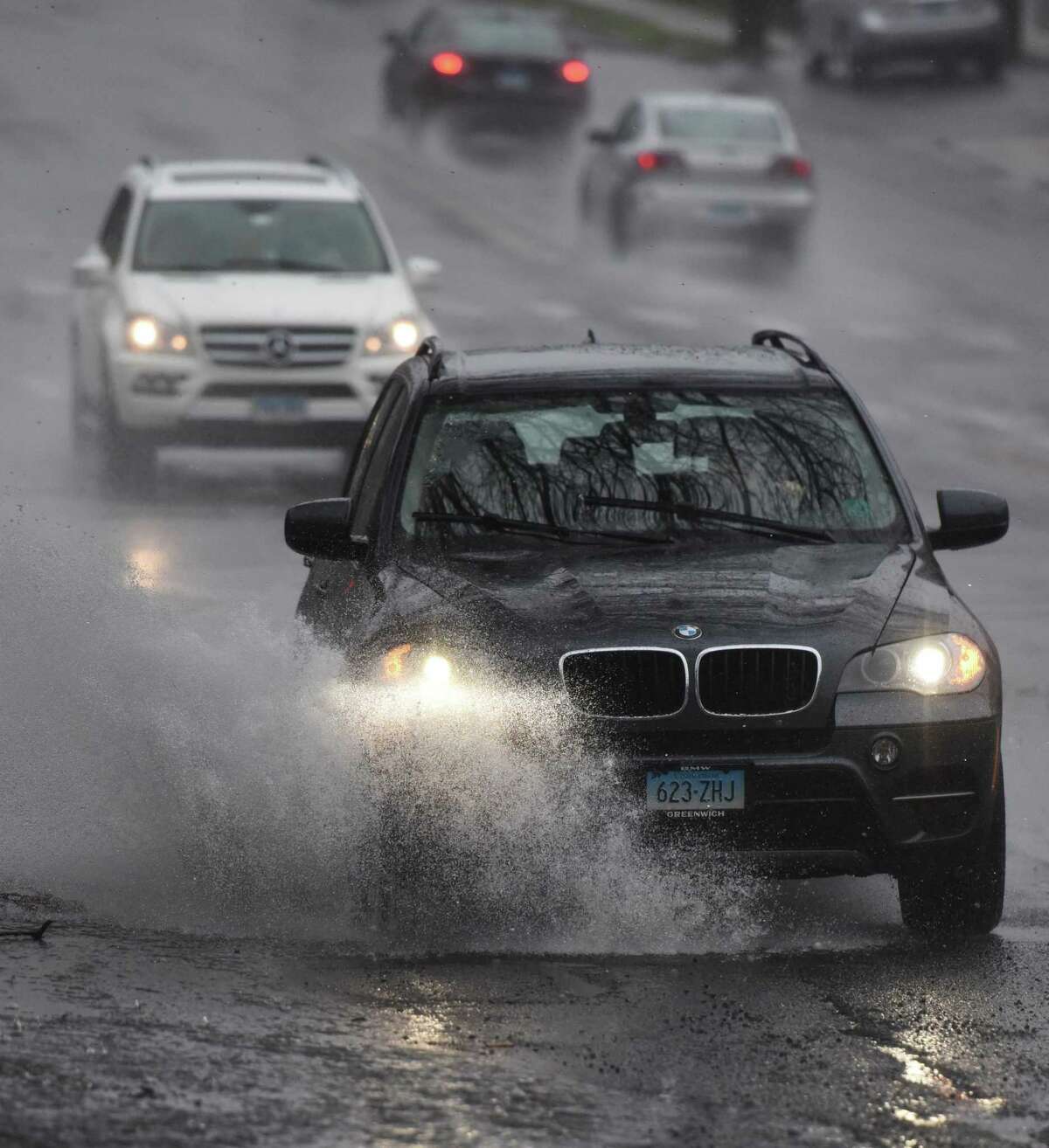 File photo of a vehicle driving through a puddle along Post Road in the Riverside section of Greenwich, Conn., taken on Monday, April 20, 2015.