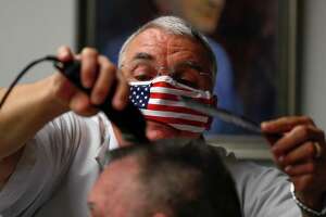 Owner Leon Apostolo carefully shapes a flat top for a customer at Shepard's Barber Shop, Friday, May 8, 2020, in Conroe. Gov. Greg Abbott modified his initial executive order to reopen the Texas economy on Tuesday to allow barbershops, nail salons and hairdressers to reopen Friday with some social distancing and hygiene protocols.
